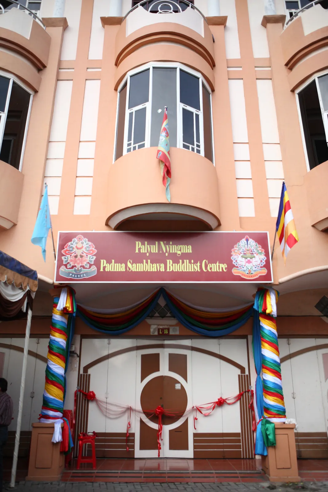 Fasad vihara pada hari peresmian, dihiasi kain lima warna dan bendera Buddhis di kedua sisi pintu masuk.