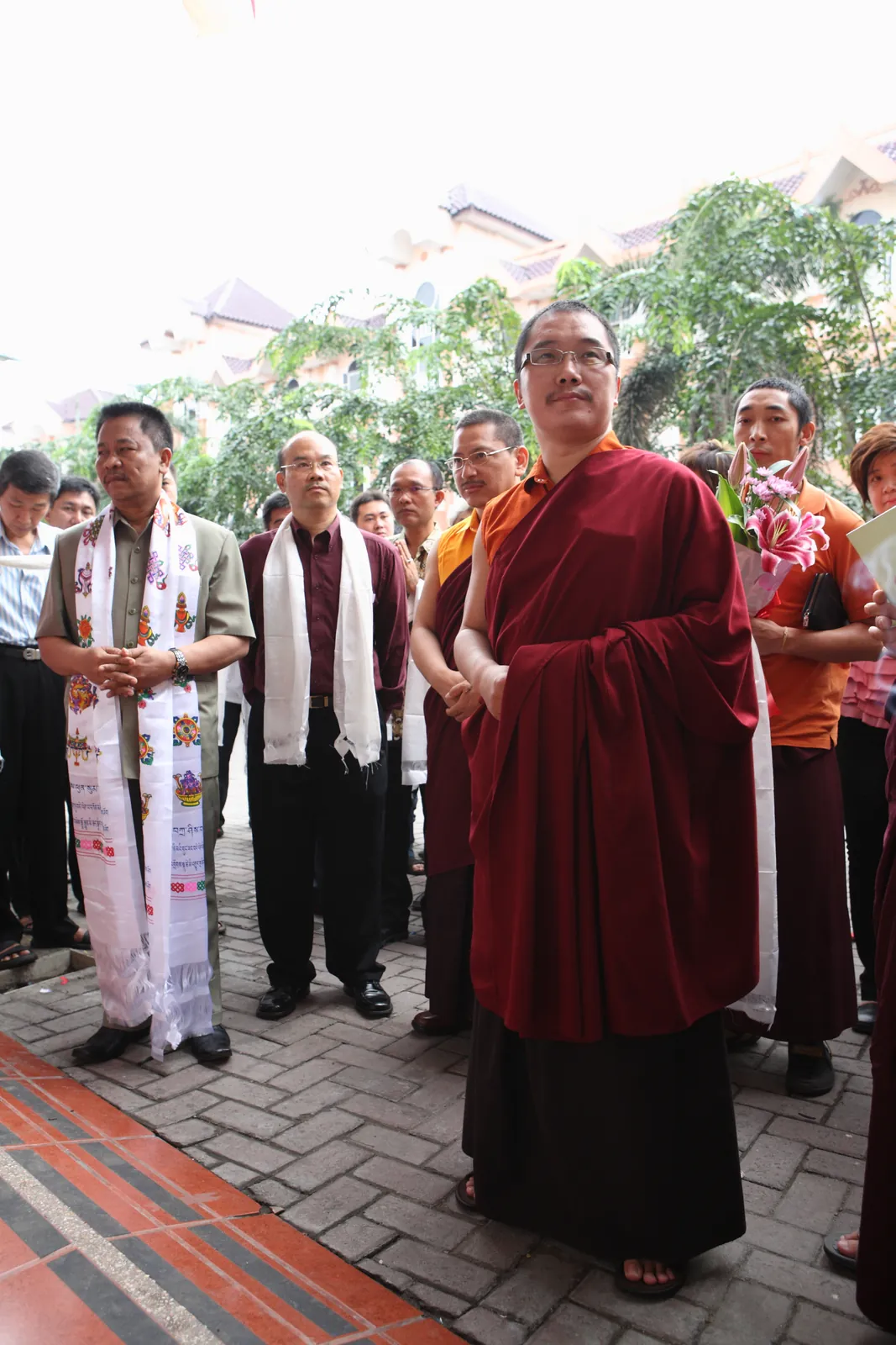 Kedatangan Yang Mulia Karma Kuchen Rinpoche, disambut umat yang mengenakan khata, selendang persembahan berwarna putih.