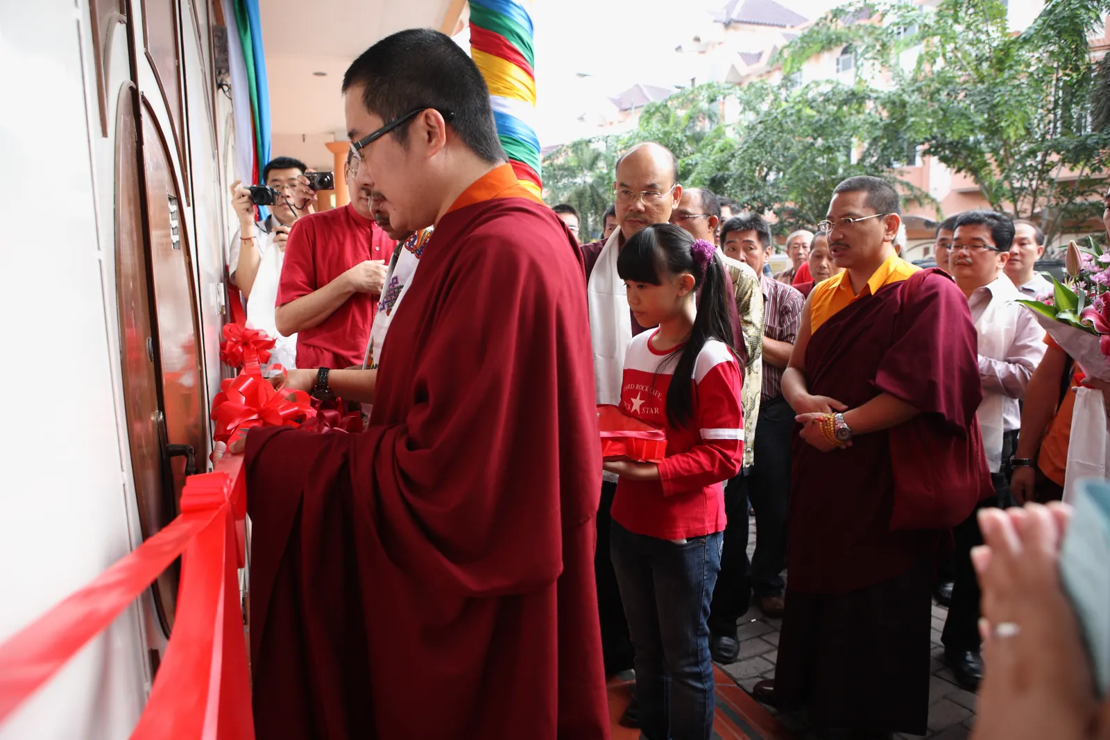 Pengguntingan pita di pintu masuk vihara oleh Yang Mulia Karma Kuchen Rinpoche.