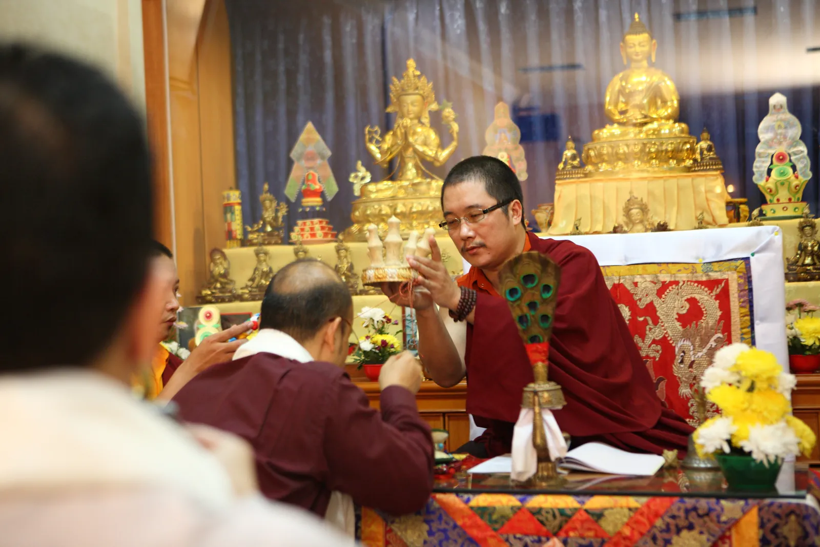 Upacara pemberkatan yang dipimpin Rinpoche, disertai persembahan di hadapan altar.