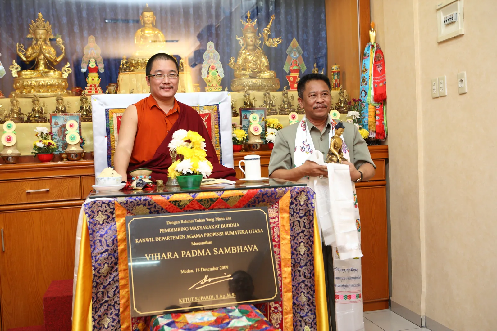 Yang Mulia Karma Kuchen Rinpoche bersama pejabat Kantor Wilayah Departemen Agama Provinsi Sumatera Utara, dengan prasasti peresmian terpampang di hadapan mereka.